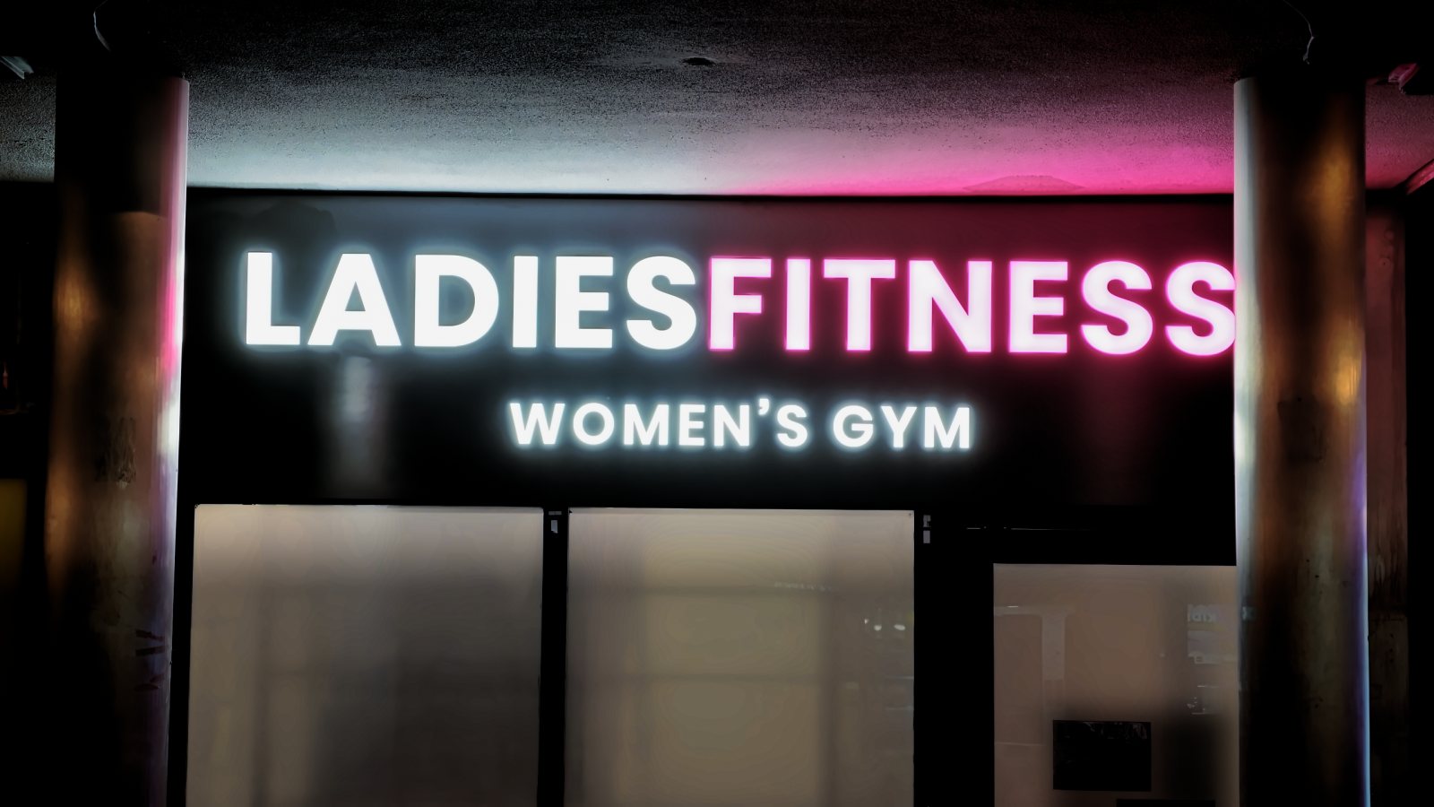 Ladies Fitness sign lit in white and pink