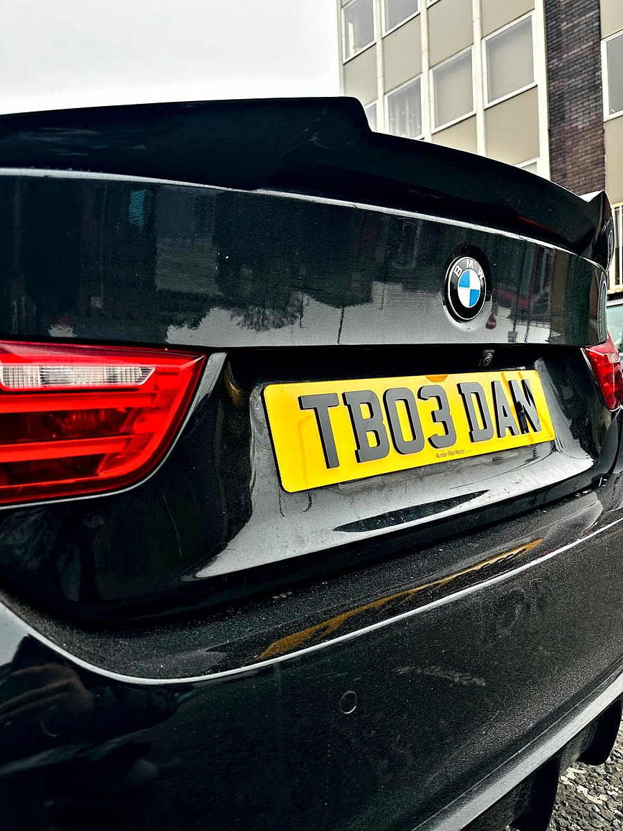 Yellow rear plate with raised black letters on a black BMW