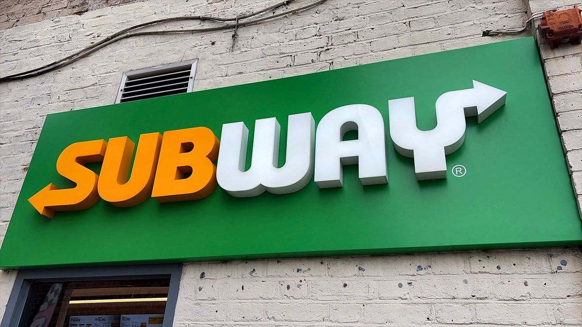 Subway sign: orange and white built-up letters on a green tray