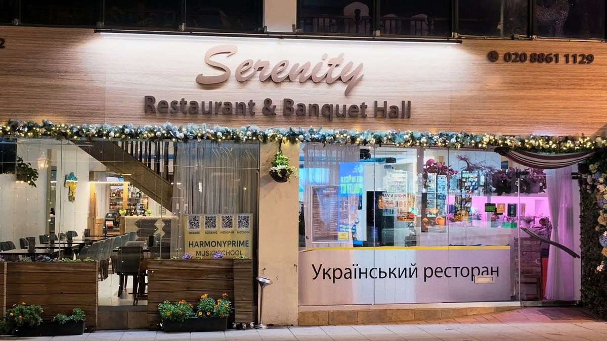 Serenity Restaurant & Banquet Hall front at night, metal script letters on timber cladding