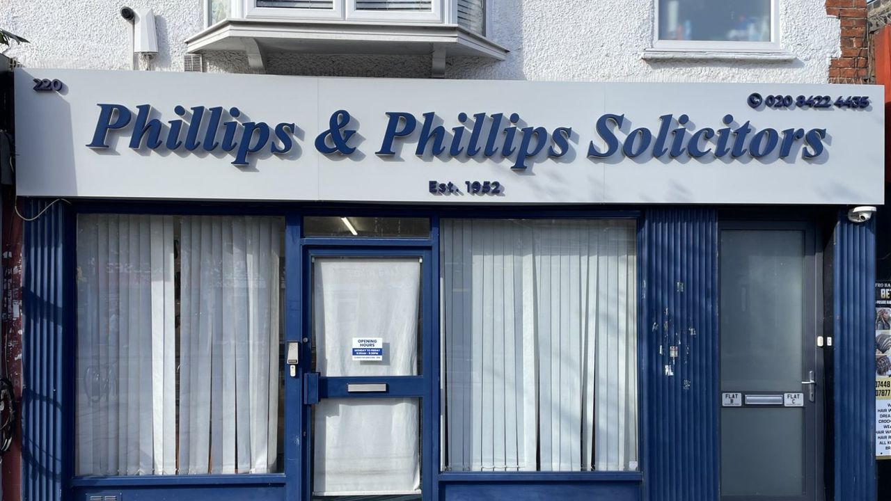 Phillips & Phillips Solicitors shop front by day, navy built-up letters on a grey fascia