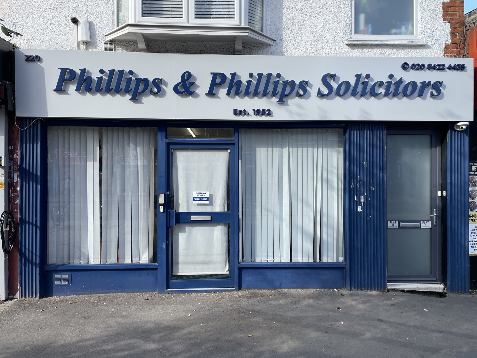 Phillips & Phillips Solicitors fascia by day, navy built-up letters on a grey panel